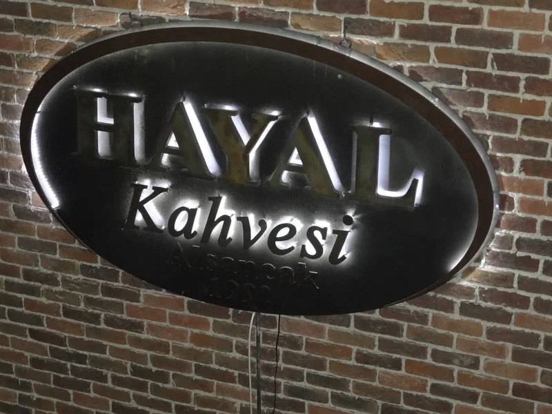 Tuğla duvarda arkadan aydınlatmalı paslanmaz kutu harf tabela